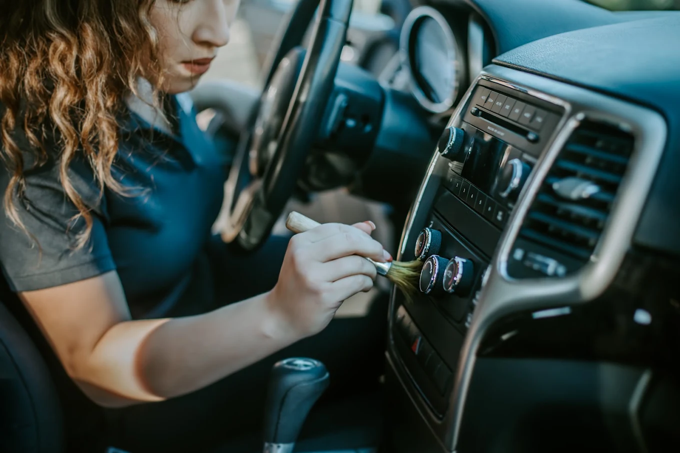 Founder detailing a car interior with a soft brush during an early detailing session